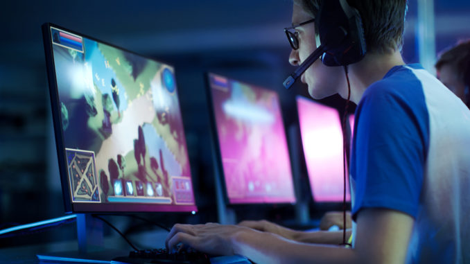 Team of Professional eSport Gamers Playing in Competitive MMORPG/ Strategy Video Game on a Cyber Games Tournament. They Talk to Each other into Microphones. Arena Looks Cool with Neon Lights. Jeux video, 3 milliards de joueurs selon une etude de DFC Intelligence