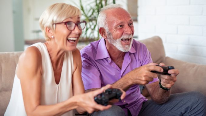Happy senior couple playing video games Jeux video, les seniors et leurs petits enfants pendant le confinement