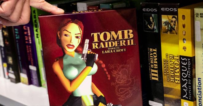 Collection-de-jeux-vidéos-à-la-BnF Disque de la série de jeux vidéo Tomb Raider 2 avec la figurine de la protagoniste Lara Croft sur le dessusConsoles, jeux en tous genres sur différents supports sont conservés à la BnF- Photography BERTRAND GUAY / AFP©