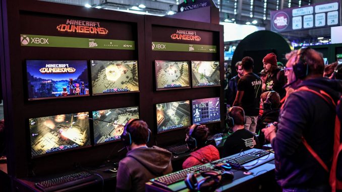 paris-games-week-retour Un moniteur multiécrans sur lequel des compétiteurs e-sport disputent des parties de Minecraft Dungeons.