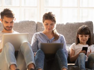 Une petite famille découvrant la joie d’utiliser un débit de connexion internet optimisée.