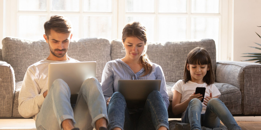 Une petite famille découvrant la joie d’utiliser un débit de connexion internet optimisée.