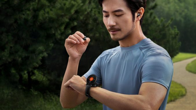 watch-buds-ecouteurs-sans-fil-materiel-gaming Un homme dans un parc en train de ranger ses écouteurs sans fil dans la montre connectée Watch Buds Huawei