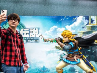 Un développeur gaming en train de prendre un selfie devant l’affiche du dernier épisode en lice du jeu vidéo Zelda.