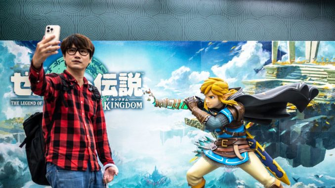zelda-inspirations-developpeurs Un développeur gaming en train de prendre un selfie devant l’affiche du dernier épisode en lice du jeu vidéo Zelda.