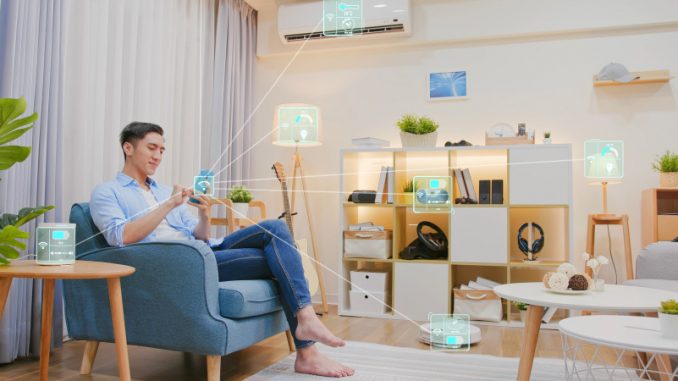 bluetooth-avec-moderation-reduction-risques-securite Un homme assis dans son salon qui, visiblement, devrait utiliser son Bluetooth avec modération pour ne pas s’exposer à des failles de sécurité.