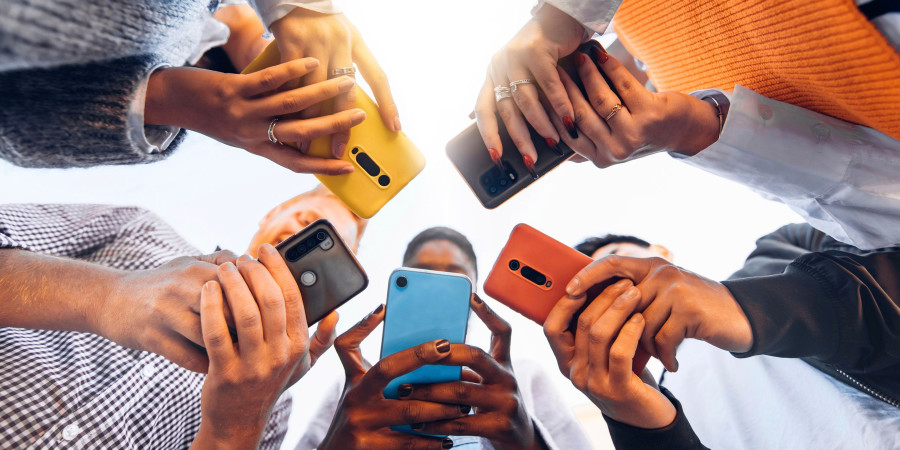 Des jeunes en rond tenant chacun dans leurs mains un smartphone pour ado.