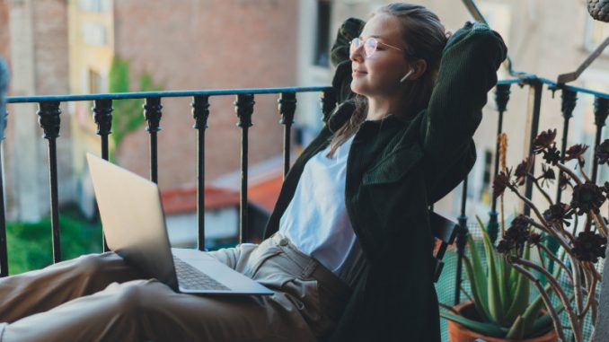 digital-nomads-villes-europe-teletravail Une femme avec son PC portable en train de travailler sur le balcon d’un hôtel, une parmi les innombrables « digital nomads » voyageant à travers l’Europe.