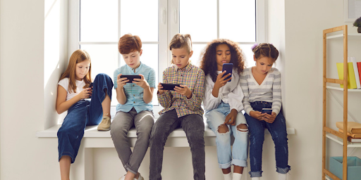 enfantss 11 12 ans Enfants de 11-12 ans jouant sur leurs smartphones, privilégiant réseaux sociaux et jeux en ligne