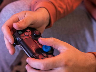 Une main tenant une manette de jeu