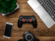 Console de jeu noire sur une surface en bois.