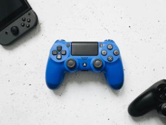 Manette de jeu bleu, noir et console portable grise.