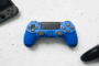 Manette de jeu bleu, noire et console portable grise.