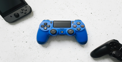 Manette de jeu bleu, noire et console portable grise. Manette de jeu bleu, noire et console portable grise.