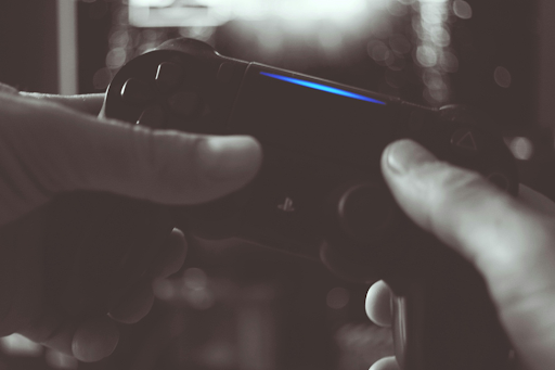 Photo en noir et blanc de l'homme tenant la manette sans fil Sony. Photo en noir et blanc de l'homme tenant la manette sans fil Sony.