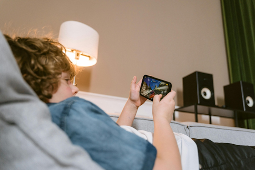 Un enfant entrain de jouer au jeu vidéo sur son smartphone.